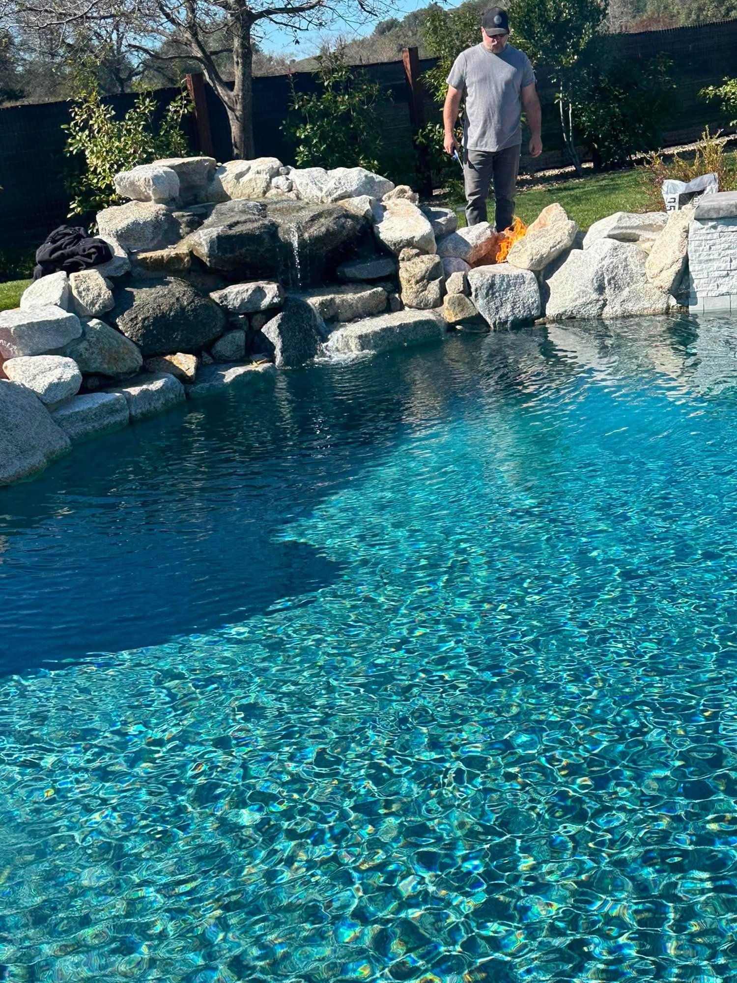 Lagoon-style pool with a natural boulder waterfall